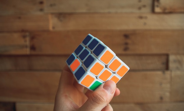 A Hand Holding A Rubik’s Cube