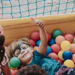 a boy and a girl in a ball pit